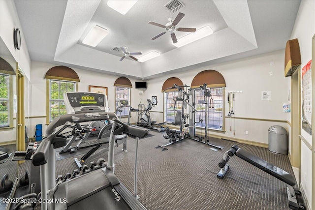 121 Lancha Cir Unit 206, Indian Harbour Beach, FL 32937 - exercise room with a tray ceiling, baseboards, ceiling fan, and a textured ceiling