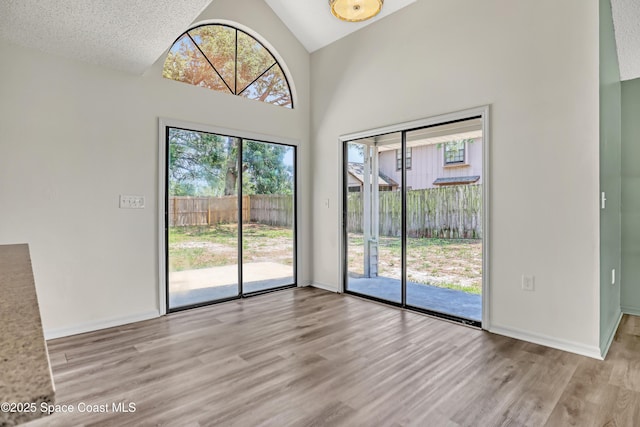 6827 Dodge Rd, Cocoa, FL 32927 - unfurnished dining area featuring wood finished floors, high vaulted ceiling, and baseboards