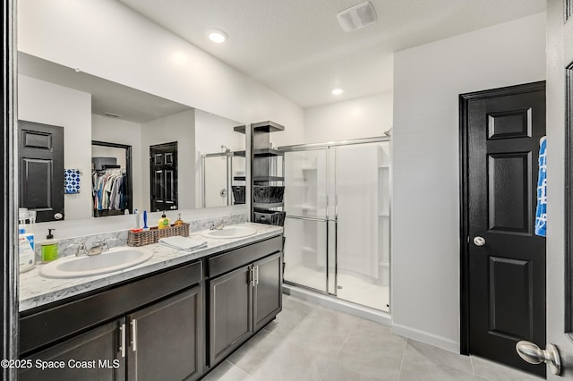 1460 Glendale Ave NW, Palm Bay, FL 32907 - full bath featuring a stall shower, double vanity, a walk in closet, and tile patterned flooring