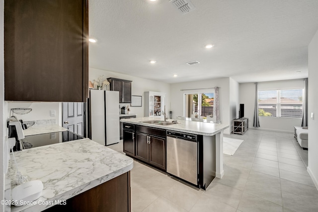 1460 Glendale Ave NW, Palm Bay, FL 32907 - kitchen with stainless steel dishwasher, freestanding refrigerator, a sink, dark brown cabinets, and recessed lighting