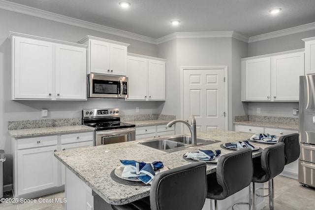 738 Old Country SE, Palm Bay, FL 32909 - kitchen with appliances with stainless steel finishes, a sink, a breakfast bar area, a center island with sink, and white cabinets