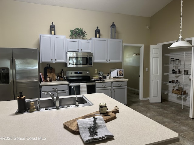 2259 Cogan Dr, Palm Bay, FL 32909 - kitchen featuring appliances with stainless steel finishes, decorative light fixtures, light countertops, a sink, and baseboards