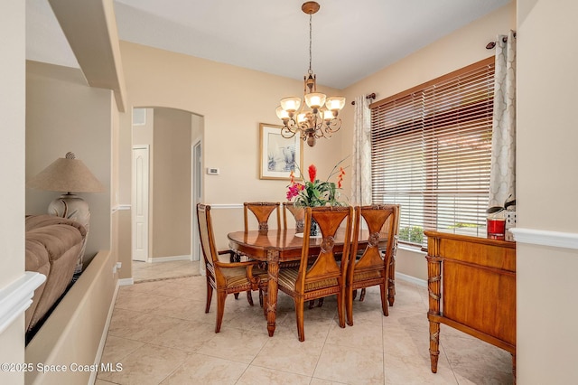 208 Chello Ave, Sebastian, FL 32958 - dining space featuring arched walkways, a chandelier, light tile patterned floors, and baseboards