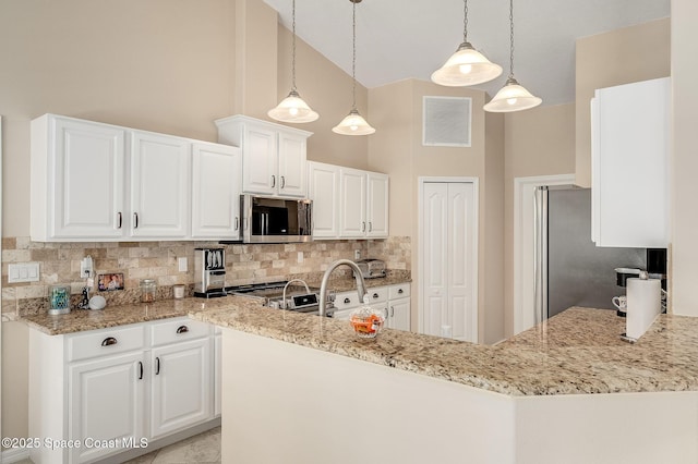 208 Chello Ave, Sebastian, FL 32958 - kitchen with stainless steel appliances, decorative backsplash, light stone countertops, high vaulted ceiling, and white cabinetry