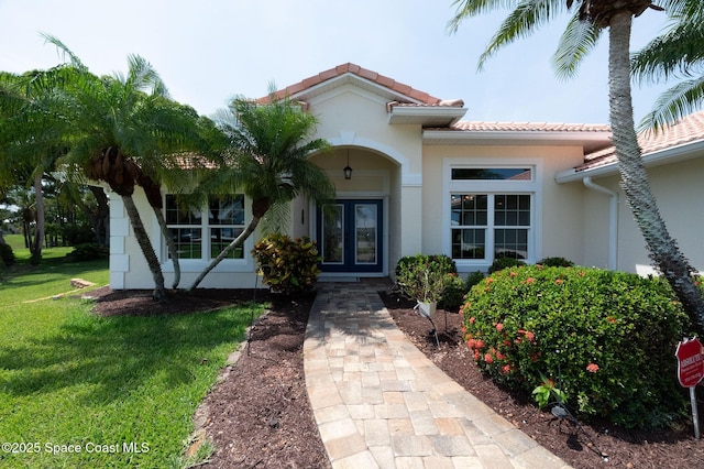 208 Chello Ave, Sebastian, FL 32958 - property entrance featuring french doors, stucco siding, a yard, and a tiled roof