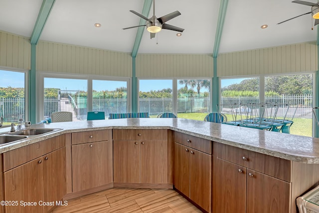 4000 Ocean Beach Blvd Unit 1J, Cocoa Beach, FL 32931 - kitchen featuring a ceiling fan, light countertops, light wood-style floors, a sink, and healthy amount of natural light