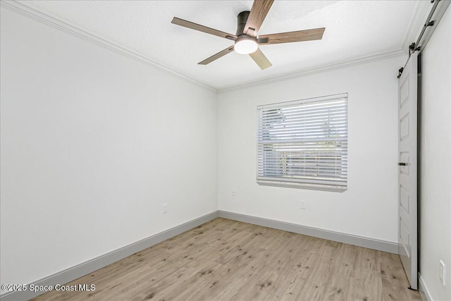 1020 Sycamore Dr, Rockledge, FL 32955 - unfurnished room with a barn door, light wood-type flooring, crown molding, ceiling fan, and baseboards