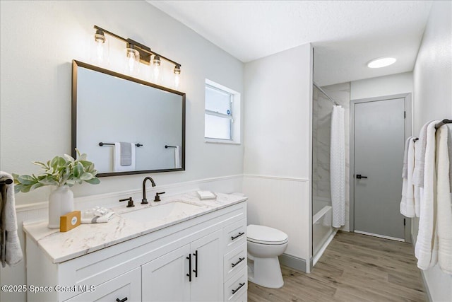 1020 Sycamore Dr, Rockledge, FL 32955 - bathroom featuring vanity, toilet, wood finished floors, a wainscoted wall, and shower / bathtub combination with curtain