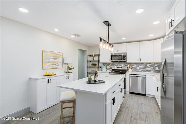 1020 Sycamore Dr, Rockledge, FL 32955 - kitchen with appliances with stainless steel finishes, light wood-type flooring, light countertops, white cabinets, and recessed lighting