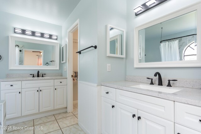 1770 Monrovia St NW, Palm Bay, FL 32907 - bathroom with a wainscoted wall, two vanities, and tile patterned flooring