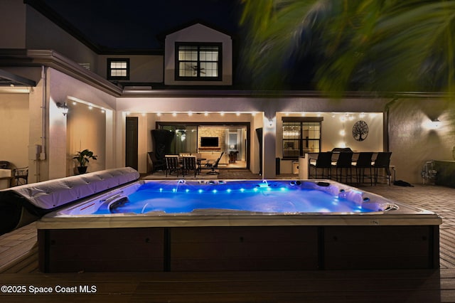 2291 Trava Ln, Melbourne, FL 32940 - pool at twilight featuring an outdoor hot tub, a patio area, and an outdoor bar