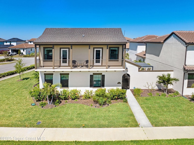 2291 Trava Ln, Melbourne, FL 32940 - view of property with a balcony, a front lawn, and stucco siding