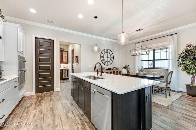 2291 Trava Ln, Melbourne, FL 32940 - kitchen with a sink, appliances with stainless steel finishes, an island with sink, light wood-style flooring, and hanging light fixtures