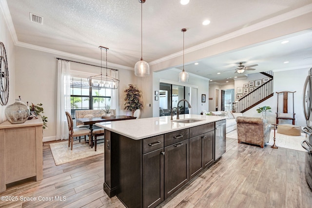 2291 Trava Ln, Melbourne, FL 32940 - kitchen with a sink, stainless steel dishwasher, light wood-style floors, light countertops, and an island with sink