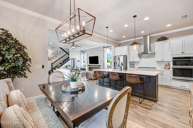 2291 Trava Ln, Melbourne, FL 32940 - dining space with stairs, recessed lighting, ornamental molding, light wood-style flooring, and a ceiling fan