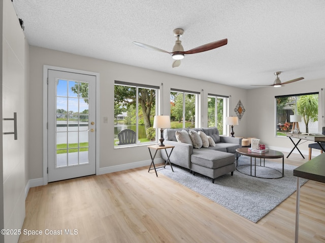1750 Old Glory Blvd, Melbourne, FL 32940 - living room featuring ceiling fan, wood finished floors, a textured ceiling, and baseboards