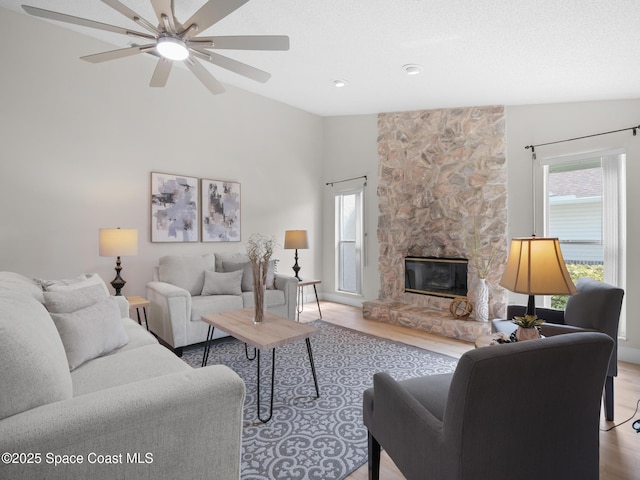1750 Old Glory Blvd, Melbourne, FL 32940 - living area featuring light wood finished floors, a ceiling fan, high vaulted ceiling, and a stone fireplace