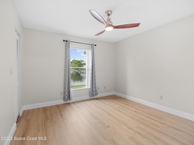 1750 Old Glory Blvd, Melbourne, FL 32940 - empty room featuring light wood-style floors, baseboards, ceiling fan, and a water view