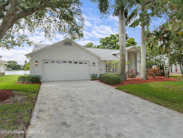 1750 Old Glory Blvd, Melbourne, FL 32940 - view of front of property with stucco siding, a garage, decorative driveway, and a front yard