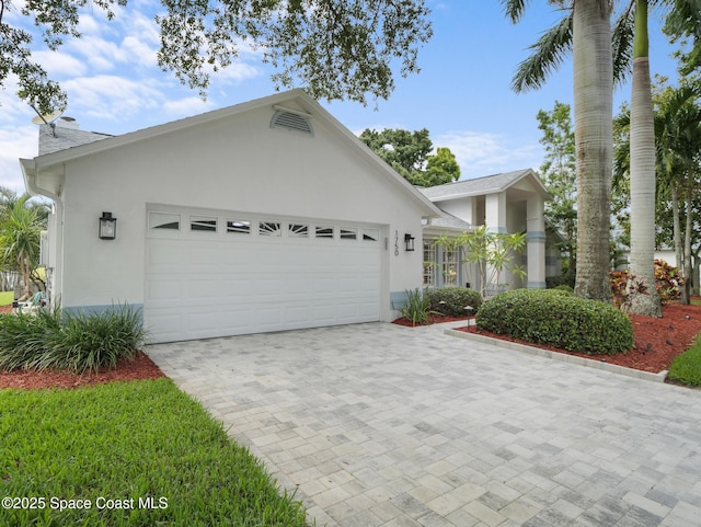 1750 Old Glory Blvd, Melbourne, FL 32940 - view of front of home with stucco siding, an attached garage, and decorative driveway