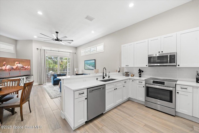120 Mediterranean Way, Indian Harbour Beach, FL 32937 - kitchen featuring stainless steel appliances, a peninsula, light countertops, tasteful backsplash, and a ceiling fan
