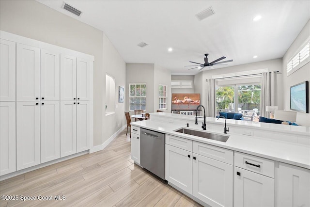 120 Mediterranean Way, Indian Harbour Beach, FL 32937 - kitchen with stainless steel dishwasher, a ceiling fan, light countertops, white cabinetry, and light wood-style flooring