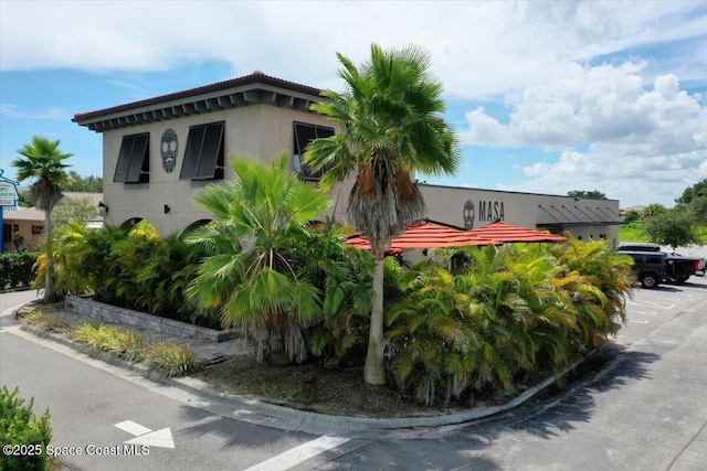 120 Mediterranean Way, Indian Harbour Beach, FL 32937 - view of property exterior featuring uncovered parking and stucco siding