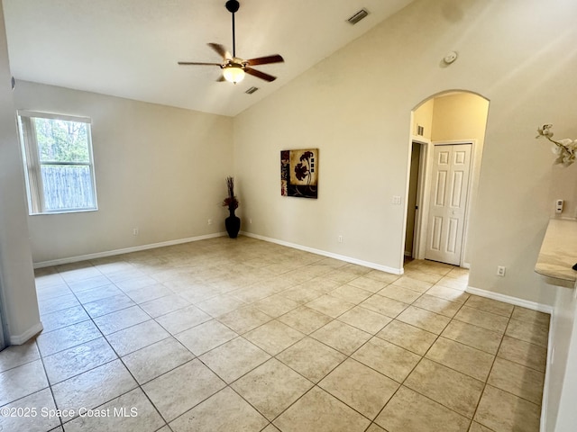2601 Diane Ave SE, Palm Bay, FL 32909 - empty room with arched walkways, light tile patterned floors, a ceiling fan, baseboards, and high vaulted ceiling