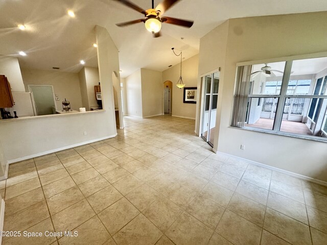 2601 Diane Ave SE, Palm Bay, FL 32909 - unfurnished living room featuring ceiling fan, tile patterned floors, baseboards, arched walkways, and vaulted ceiling