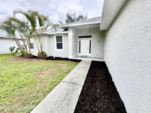 2601 Diane Ave SE, Palm Bay, FL 32909 - view of exterior entry with stucco siding and a yard