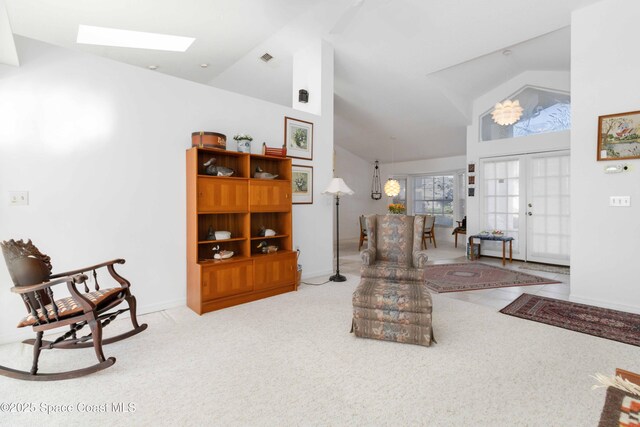1181 Cypress Trace Dr, Melbourne, FL 32940 - carpeted living room featuring high vaulted ceiling, a skylight, and baseboards