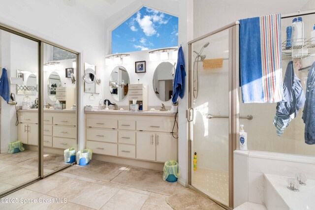 1181 Cypress Trace Dr, Melbourne, FL 32940 - bathroom with a shower stall, a bath, double vanity, vaulted ceiling, and tile patterned flooring