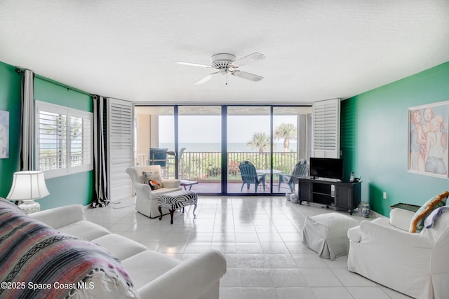1527 S Atlantic Ave Unit 201, Cocoa Beach, FL 32931 - living area featuring ceiling fan, tile patterned flooring, and expansive windows