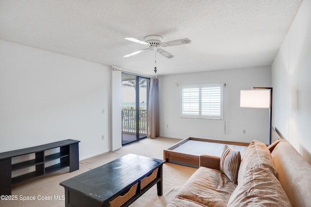 1527 S Atlantic Ave Unit 201, Cocoa Beach, FL 32931 - living room featuring a ceiling fan, a textured ceiling, and light colored carpet