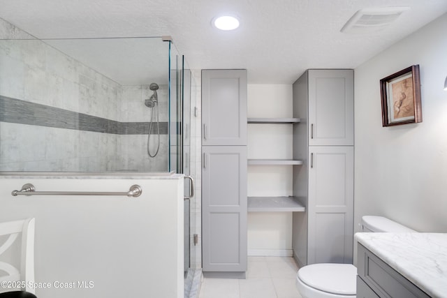 1527 S Atlantic Ave Unit 201, Cocoa Beach, FL 32931 - bathroom with a shower stall, toilet, tile patterned flooring, vanity, and a textured ceiling