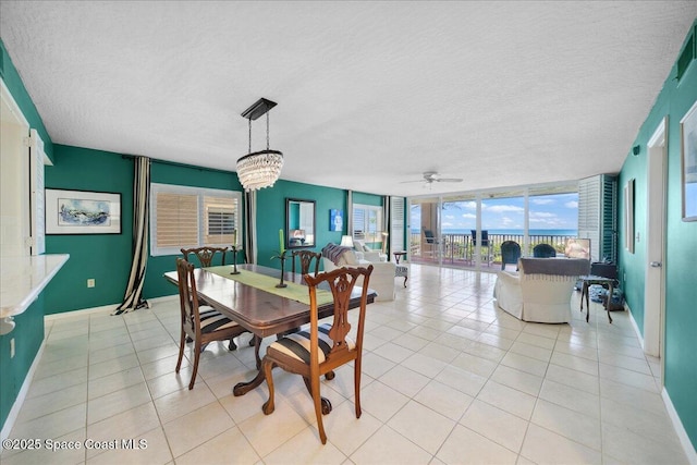 1527 S Atlantic Ave Unit 201, Cocoa Beach, FL 32931 - dining space featuring a textured ceiling, a chandelier, a ceiling fan, light tile patterned floors, and a wall of windows