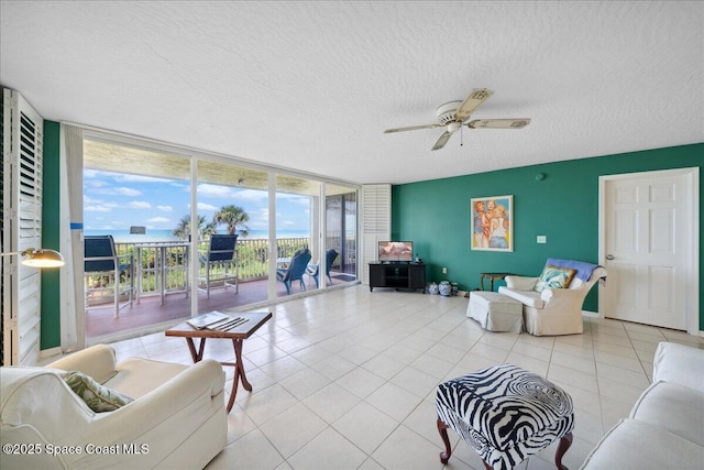 1527 S Atlantic Ave Unit 201, Cocoa Beach, FL 32931 - living room featuring floor to ceiling windows, a textured ceiling, ceiling fan, and light tile patterned floors