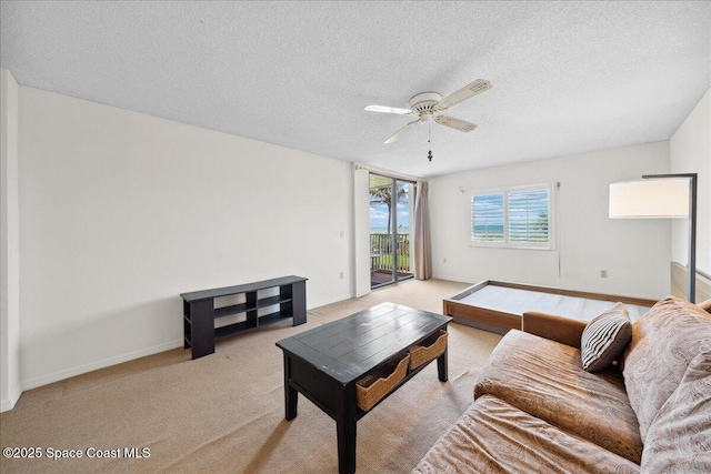 1527 S Atlantic Ave Unit 201, Cocoa Beach, FL 32931 - living area with a ceiling fan, a textured ceiling, and light carpet