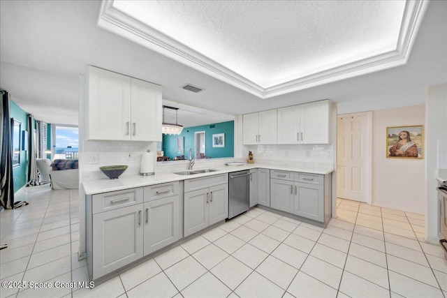 1527 S Atlantic Ave Unit 201, Cocoa Beach, FL 32931 - kitchen featuring stainless steel dishwasher, gray cabinets, a raised ceiling, tasteful backsplash, and light countertops