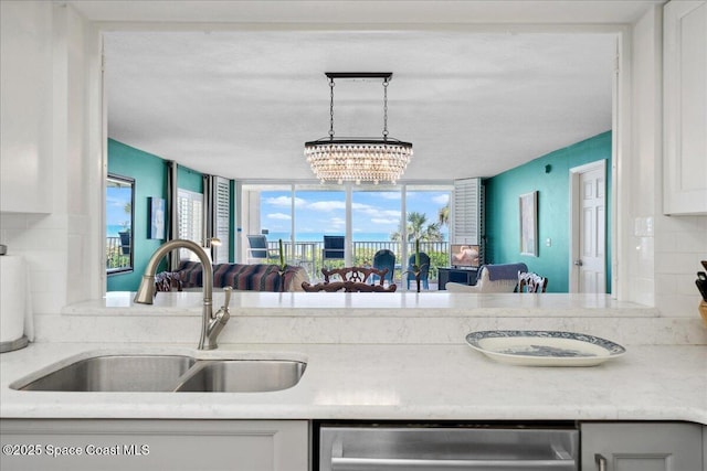 1527 S Atlantic Ave Unit 201, Cocoa Beach, FL 32931 - kitchen featuring stainless steel dishwasher, a chandelier, light countertops, white cabinets, and open floor plan