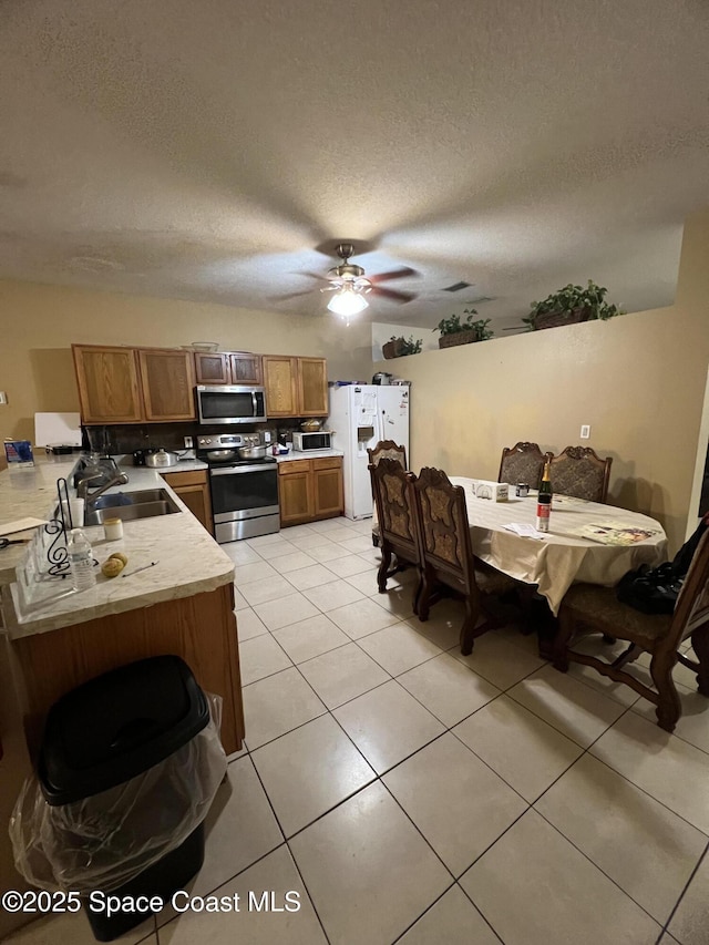 2642 Fleming Ave SW, Palm Bay, FL 32908 - kitchen with appliances with stainless steel finishes, a sink, light countertops, light tile patterned floors, and ceiling fan