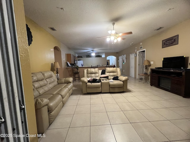 2642 Fleming Ave SW, Palm Bay, FL 32908 - living area with arched walkways, light tile patterned floors, a ceiling fan, and a textured ceiling