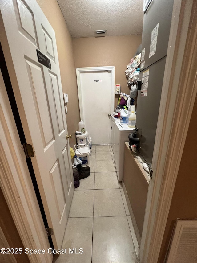2642 Fleming Ave SW, Palm Bay, FL 32908 - laundry room featuring washer and dryer, a textured ceiling, and light tile patterned flooring