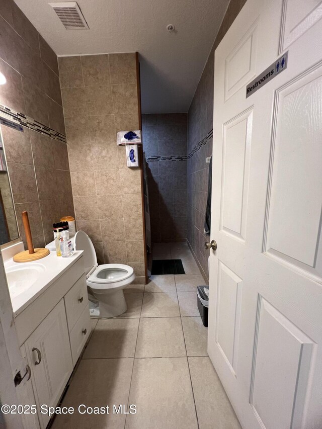 2642 Fleming Ave SW, Palm Bay, FL 32908 - full bath with tile walls, vanity, tile patterned floors, and toilet