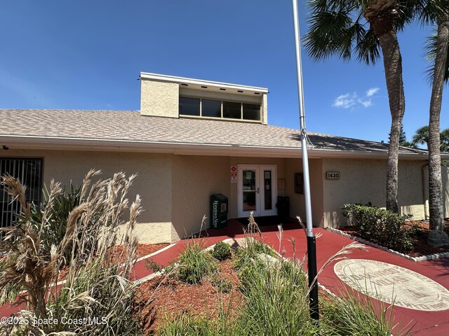1021 Abada Ct NE Unit 106, Palm Bay, FL 32905 - view of front of property with stucco siding, roof with shingles, and french doors