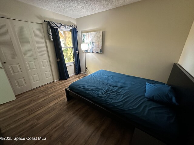 1021 Abada Ct NE Unit 106, Palm Bay, FL 32905 - bedroom with wood finished floors, a textured ceiling, a closet, and baseboards