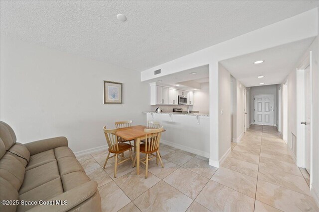 1825 Riverside Dr Unit 205, Titusville, FL 32780 - dining room featuring a textured ceiling and recessed lighting