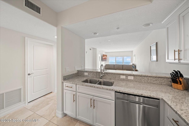 1825 Riverside Dr Unit 205, Titusville, FL 32780 - kitchen with stainless steel dishwasher, a sink, light stone counters, light tile patterned floors, and white cabinetry