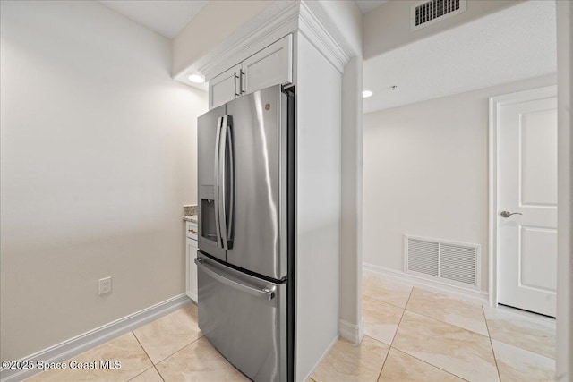 1825 Riverside Dr Unit 205, Titusville, FL 32780 - kitchen with stainless steel refrigerator with ice dispenser, light tile patterned flooring, baseboards, and white cabinetry