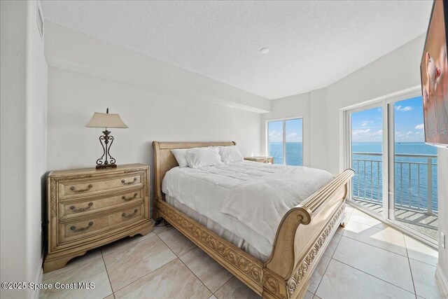 1825 Riverside Dr Unit 205, Titusville, FL 32780 - bedroom featuring access to exterior, a water view, and a textured ceiling